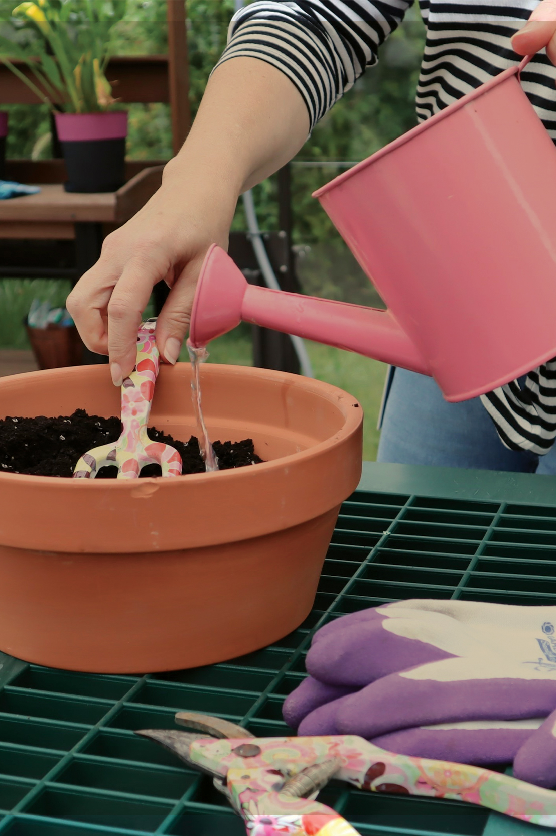 Woman Watering and Raking a Flower Pot